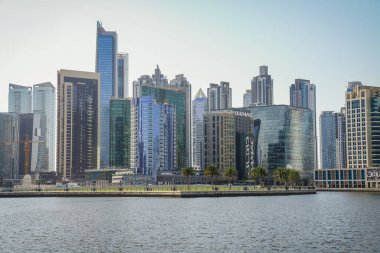 Business Bay Kanalı. Dubai, BAE 'de modern mimari ve cam cephelerini gösteren yüksek çözünürlüklü gündüz fotoğrafı..