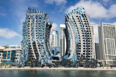 J-1 binası Business Bay Kanalı 'nın karşısında. Dubai, BAE 'de, modern, kıvrımlı mimari ve cam cephesini gösteren yüksek çözünürlüklü gündüz fotoğrafı..