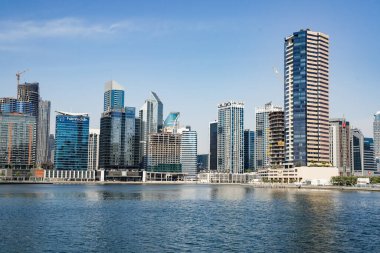 Business Bay Kanalı. Dubai, BAE 'de modern mimari ve cam cephelerini gösteren yüksek çözünürlüklü gündüz fotoğrafı..