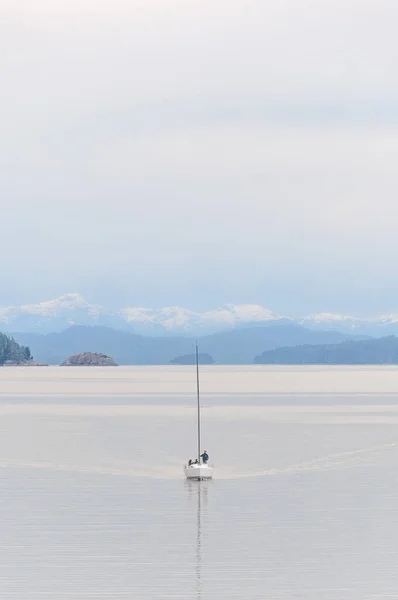 山を背に穏やかな水の中を航海する船 — ストック写真