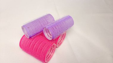 beyaz arkaplanda izole edilmiş mor ve kırmızı saç silindirleri