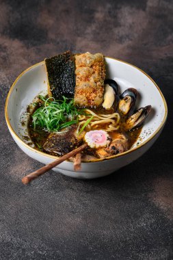 Udon erişteli Asya usulü çorba, domuz eti, karides, midye ve yeşil soğan tabakta yakın plan. Yukarıdan yatay üst görünüm