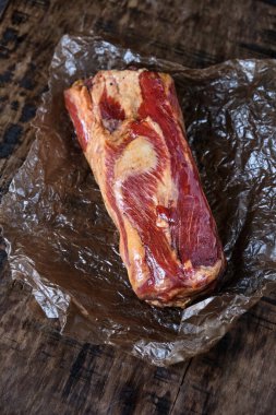 Ahşap bir kırsal masada tütsülenmiş domuz eti, organik çiftliğin doğal ürünü, geleneksel yöntemlerle üretiliyor.