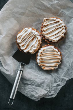 Gri sırtta üç limonlu tart ve pasta spatulası.