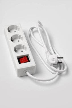 Beyaz prizler için beyaz uzatma kablosu. Işıklandırılmış elektrik şalteri beyazda izole edilmiş.