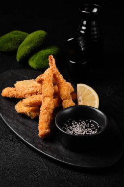 Tempura shrimp and Tempura vegetables in breadcrumbs  on black concrete background