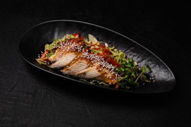 Eel salad on a black concrete background