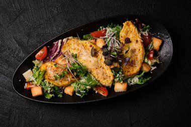 Caesar salad in Japanese stile on a black concrete background