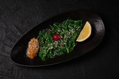 Chuka wakame salad on black concrete background. Top view