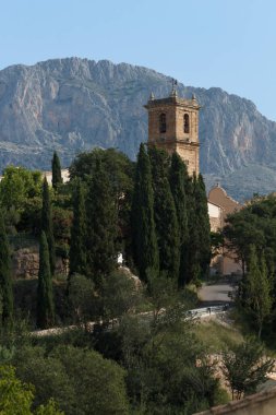 Alcocer de Planes 'in çan kulesiyle manzara ve arka planda Benicadell zirvesi, İspanya