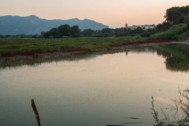 Serpis nehri üzerinde turuncu tonları ve arka planda Alcocer de Planes ve Sierra de Mariola, İspanya