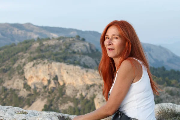 Middle aged woman with red hair looking at camera in the Alt de les Pedreres of Alcoi, Spain