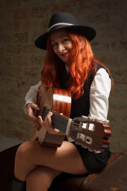 Olgun bir kadın gitar çalmayı öğreniyor. Arenales del Sol, İspanya