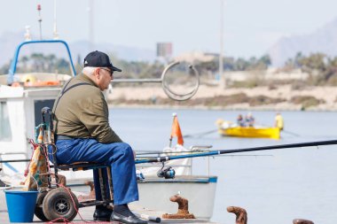 Guardamar del Segura, İspanya, 03-16-2024: Guarmar del Segura, İspanya 'da yaşlı bir adam balık tutuyor