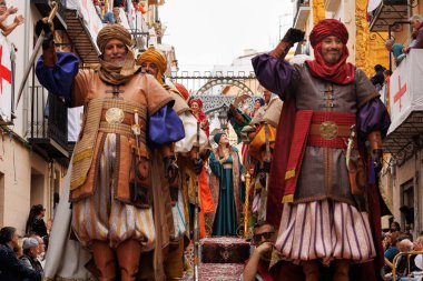 04-20-2024, Alcoy, İspanya: Mudejar grubundan şövalyeler arka plandaki bayana odaklanarak savaşa doğru ilerliyorlar. Popüler festivaller 1980 yılından bu yana uluslararası turizm çıkarlarını ilan etti