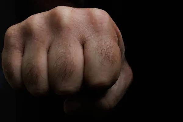 Siyah arkaplanlı yumruk tokuşturma, iki insan arasında saygı ve kutlama selamlaması..