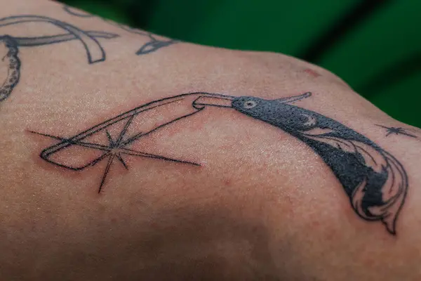 Bacağa ve dizine dövme yaparken kuaför bıçağı.