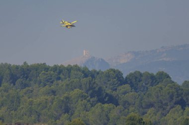 Beniarrs, İspanya, 07-31-2024; Beniarres rezervlerine deniz uçağı yaklaşımı Penaguila ve Benasau 'daki orman yangınlarının hava desteği için Cocentaina kalesi ve ormanı ile birlikte