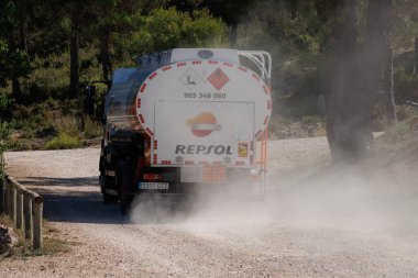 Sierra de Mariola doğal parkı, Bocairente, İspanya 'da 19 Ağustos 2024' te özel kır evleri tedarik etmek için toprak yolda yakıt nakliye kamyonu.