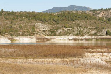 Dramatic scene due to drought in the Beniarrs reservoir with grass where there should be water, Spain clipart