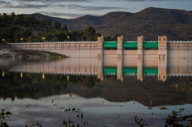 Retaining wall of Beniarres reservoir with long exposure at dusk, Spain clipart