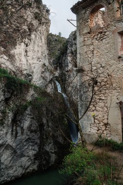 18. yüzyıldan kalma eski bir un değirmeninin kalıntıları. Şimdiki Moli del Salt yürüyüş yolu üzerinde bir şelale bulunuyor. Benilloba, İspanya.