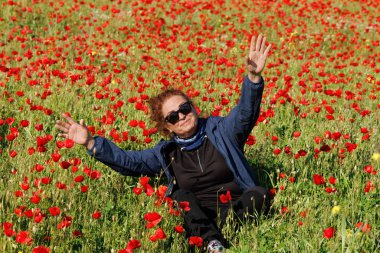 Olgun kadın baharla birlikte gelincik tarlasında oynuyor, İspanya
