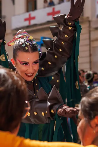 Alcoy, İspanya, 05-03-2025: Alcoy 2025 'in Moors ve Hristiyan şenliklerinde sahnelenen ve arka planda Aziz George haçı ile süslenmiş balkonların bulunduğu bir dansçının gülen yüzü