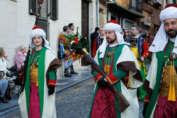 Alcoy, İspanya, 05-04-2025: Genel geçit töreninde içinde çiçekli bir blunderbuss taşıyan Magenta kumpanyası üyesi