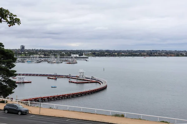 Geelong Körfezi 'nin manzarası iskele ve bulutlu gökyüzünün altında durgun denizler.