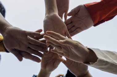 Farklı yaş ve cinsiyetlerden insanlar el ele tutuşup birlik ve desteği sembolize ediyorlar. Üretken çalışma ve olumlu sonuçlar için bir ekip oluşturuldu. Aşağıdan alındı. Yakın plan..