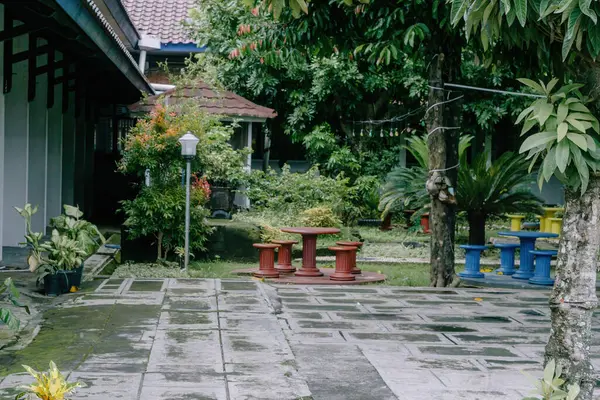 Canlı kırmızı ve mavi koltukların yemyeşil çimenlere karşı patladığı sakin arka bahçedeki vahaya kaçın..