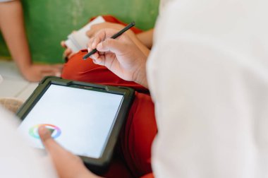 Stylus kalemle resim yapmayı öğrenen çocuklar için kullanılan ekran tabletine dokun