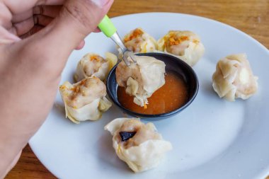 Bir tabak Dim Sum 'un yakın plan fotoğrafı. Zarif ambalajları ve dumanı tüten sıcak dolguyu sergiliyor.