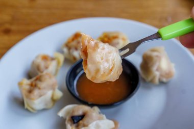 Bir tabak Dim Sum 'un yakın plan fotoğrafı. Zarif ambalajları ve dumanı tüten sıcak dolguyu sergiliyor.