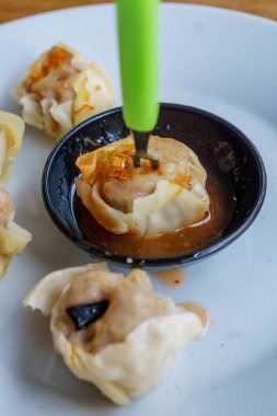 Bir tabak Dim Sum 'un yakın plan fotoğrafı. Zarif ambalajları ve dumanı tüten sıcak dolguyu sergiliyor.