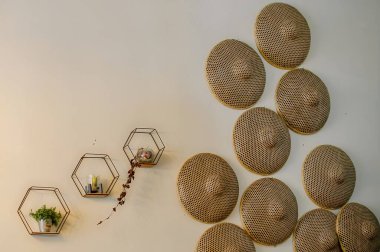 Tarafsız bir arka planda, Japon dokuma şapkası ve canlı yeşil bir ev bitkisinin yakın plan çekimi..