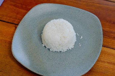 Sağlıklı beyaz pirinç, mavi-gri bir seramik tabakta servis edilir. Bir restoranda sağlıklı Endonezya yemeği.