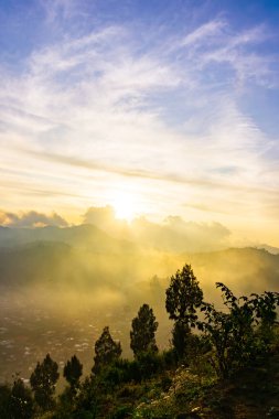 Güneşin bulutların ardında battığı bu nefes kesen görüntüyle altın saatin sihrini hissedin. Doğa, manzara ve ilham verici projeler için mükemmel..