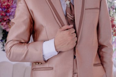 Saf erkekliğin özünü, damadın ceketini zarifçe ayarlayan elinin görüntüsüyle yakalayın..