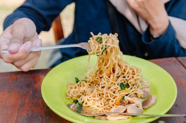 Bir insan lezzetli bir tabak Endonezya yemeği yiyor. Lezzetli ve rahatlatıcı bir şehriye yemeği. Yemek ve seyahat temaları için mükemmel.