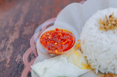 Küçük bir kase baharatlı Endonezya Sambal 'ının yakın çekimi. Her yemeğe lezzetli bir tat katan ateşli bir sos.