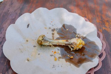 Tabakta arta kalan bir yemeğin görüntüsü, balık iskeleti ve kırıntıları, günlük yemek ve yiyecek atıklarının samimi bir görüntüsü