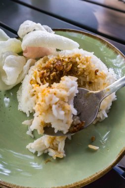 Tüylü pirinç, kızarmış soğan, kraker ve baharatlı sambal ile servis edilen baharatlı Minapadi körili tavuk. Lezzetli ve eksiksiz bir yemek.