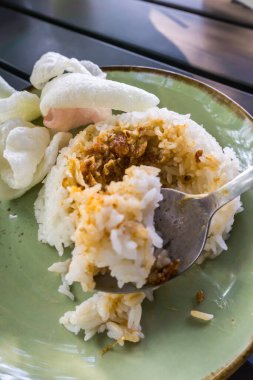 Tüylü pirinç, kızarmış soğan, kraker ve baharatlı sambal ile servis edilen baharatlı Minapadi körili tavuk. Lezzetli ve eksiksiz bir yemek.