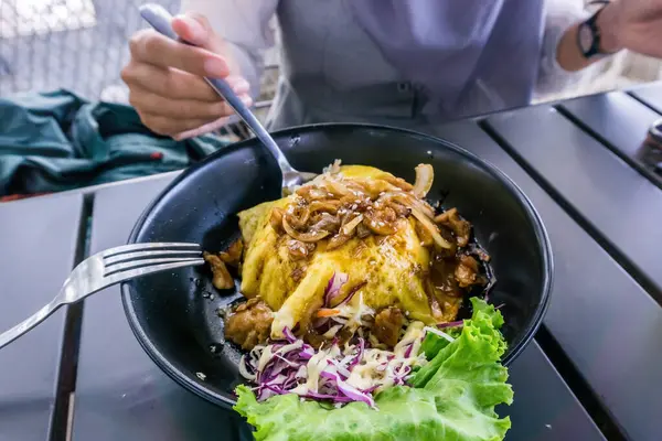 Lezzetli bir şifon yumurtalı tavuk, teriyaki, pilav ve taze salata yiyen bir kadın. Yemek, mutfak ve yaşam tarzı kavramları için mükemmel.