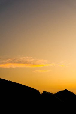 Gün batımının nefes kesen güzelliğine tanık olun. Gökyüzü renklerle dolup taşarken bulutları altın, turuncu ve pembe renklerle boyuyor..