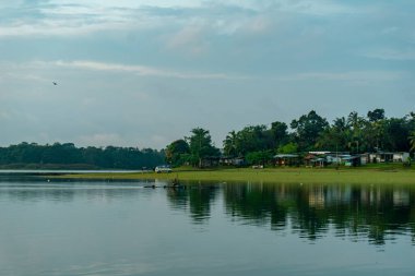 Pati, Endonezya - 8 Şubat 2025: Tüylü bulutlarla benekli canlı mavi gökyüzünü yansıtan el değmemiş bir gölün dingin güzelliğini yakala.