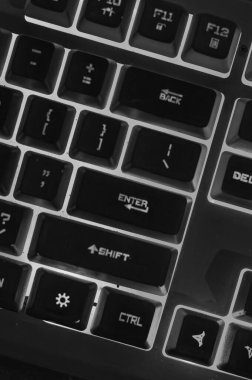 Pırıl pırıl arka planı olan parlak siyah beyaz bir klavye. Teknoloji meraklıları için mükemmel. Tasarım, oyun veya kodlama projeleri için ideal
