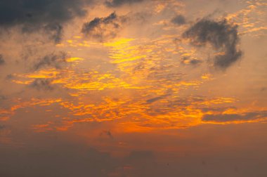 Karanlık fırtına bulutları ile dramatik turuncu günbatımı gökyüzü, nefes kesen bir ışık ve gölge karışımı yakalıyor. Değişim, ruh hali ve doğal güzellik temaları için ideal.